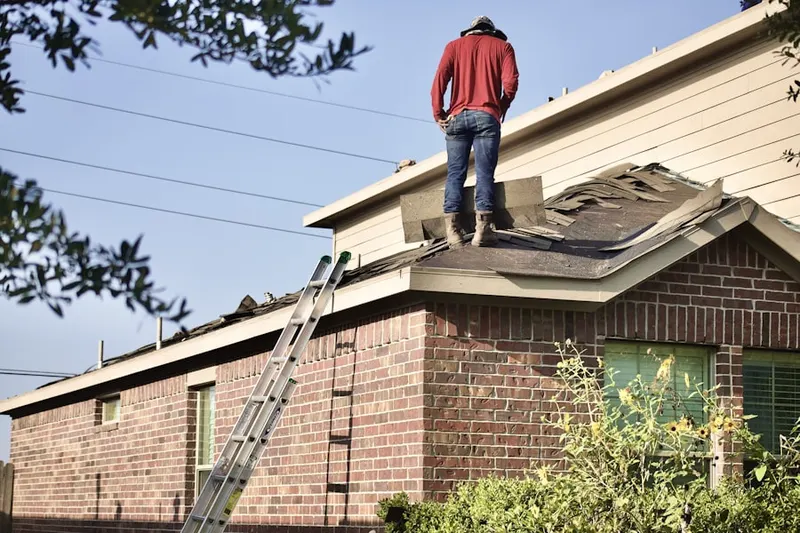 Professional roofer working on a residential roof in Laroche